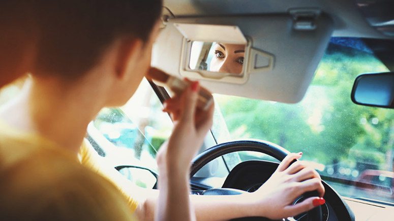 Adult Woman Putting On Makeup in The Car - Distracted Driver Accident Lawyer in California - Johnson Attorneys Group